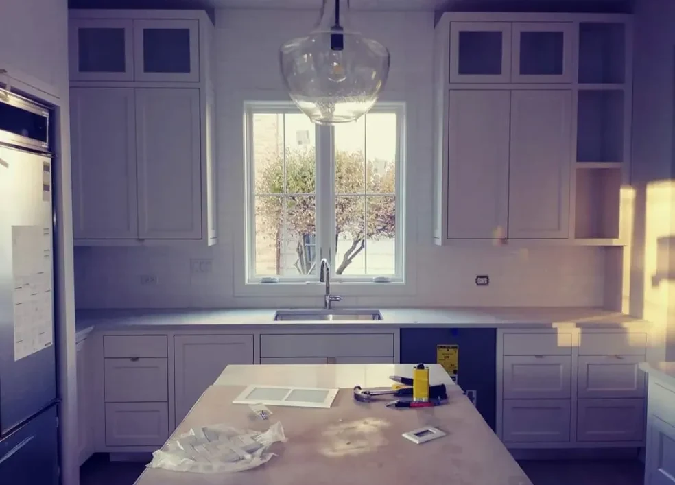 A kitchen near handover, with notes and tools still on the island