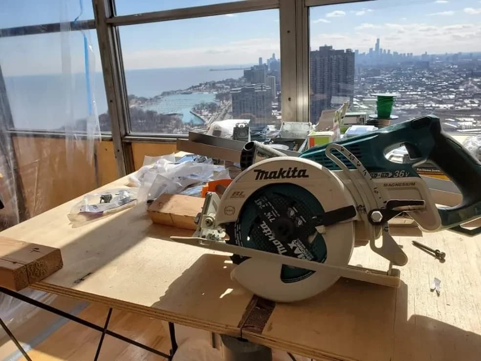 A circular saw on a work table high above the city and the lake