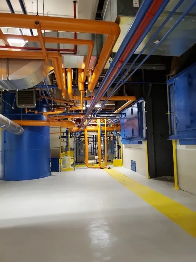 A mechanical room with orange and blue piping